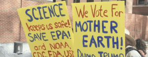 Environmental advocacy signs. The first one reads Science keeps us safe! SAVE EPA! and NOAA, CDC, US... The second one reads: We Vote For MOTHER EARTH! Dump Trump!